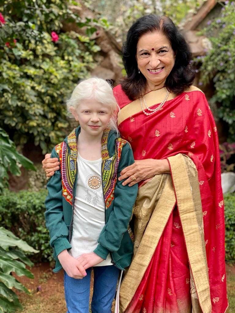 Dr. Prabha Choksey standing with a young girl with albinism